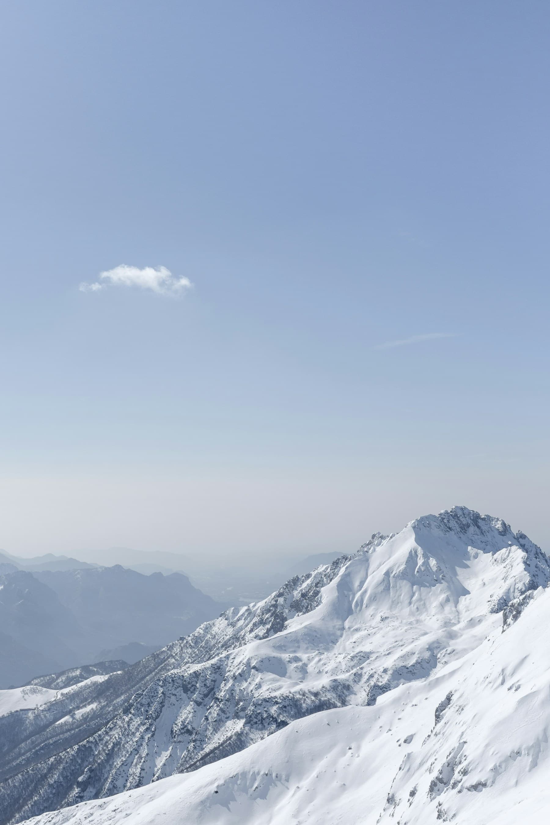 Snow-covered alpine peaks rising through clouds